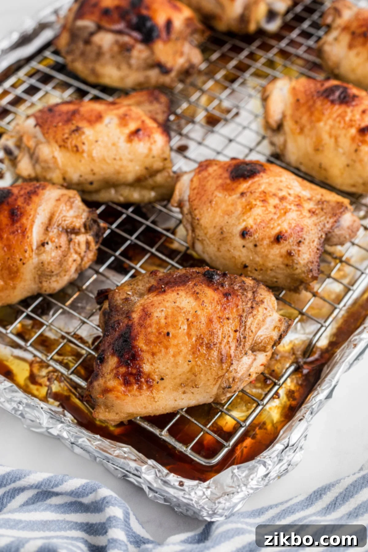 Baked chicken thighs on a wire baking rack.