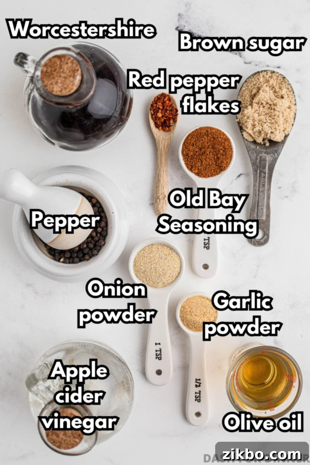 The ingredients needed to make chicken marinade: brown sugar, worcestershire sauce, red pepper flakes, apple cider vinegar, olive oil, and various seasonings, all laid out.