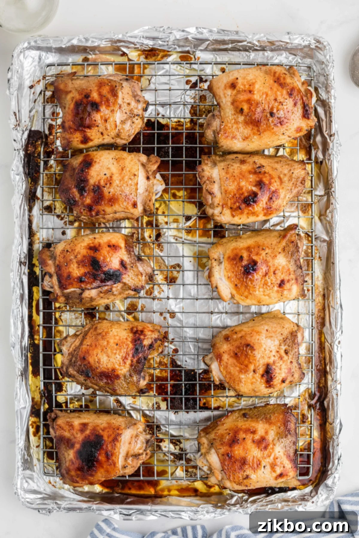Step 7: Golden-brown, perfectly baked chicken thighs emerging from the oven, with visibly crispy skin.