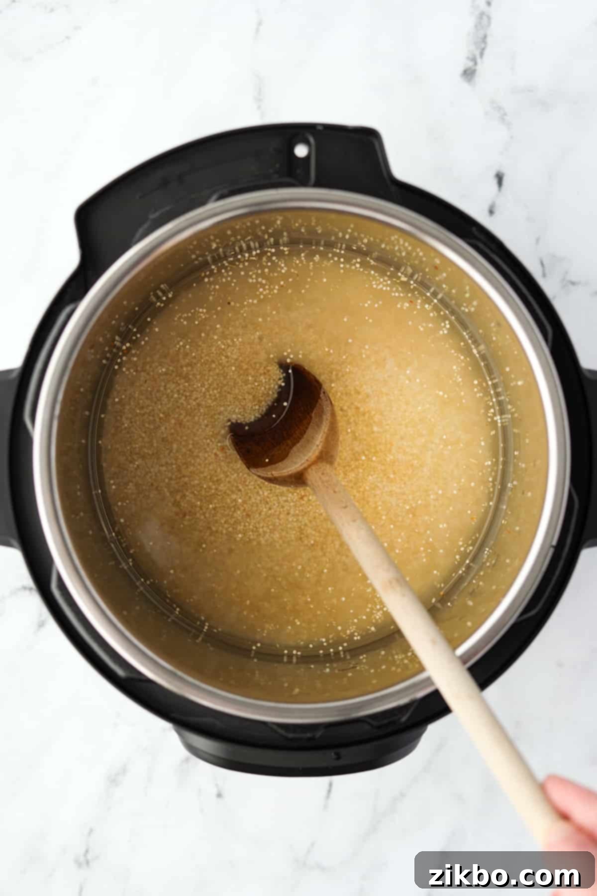 Perfect Fluffy Instant Pot Quinoa 4 Stirring an Instant Pot with quinoa.