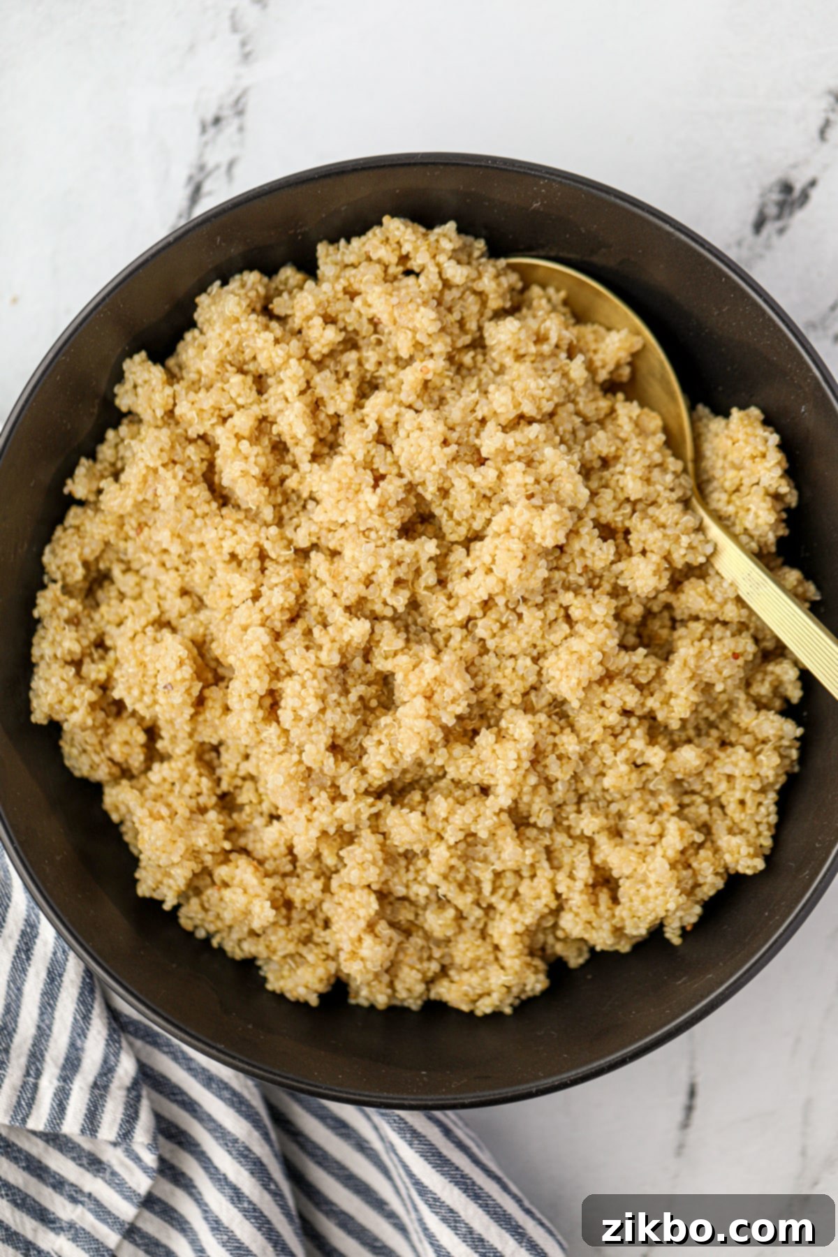 Perfect Fluffy Instant Pot Quinoa 6 A golden spoon scooping quinoa from a black bowl.