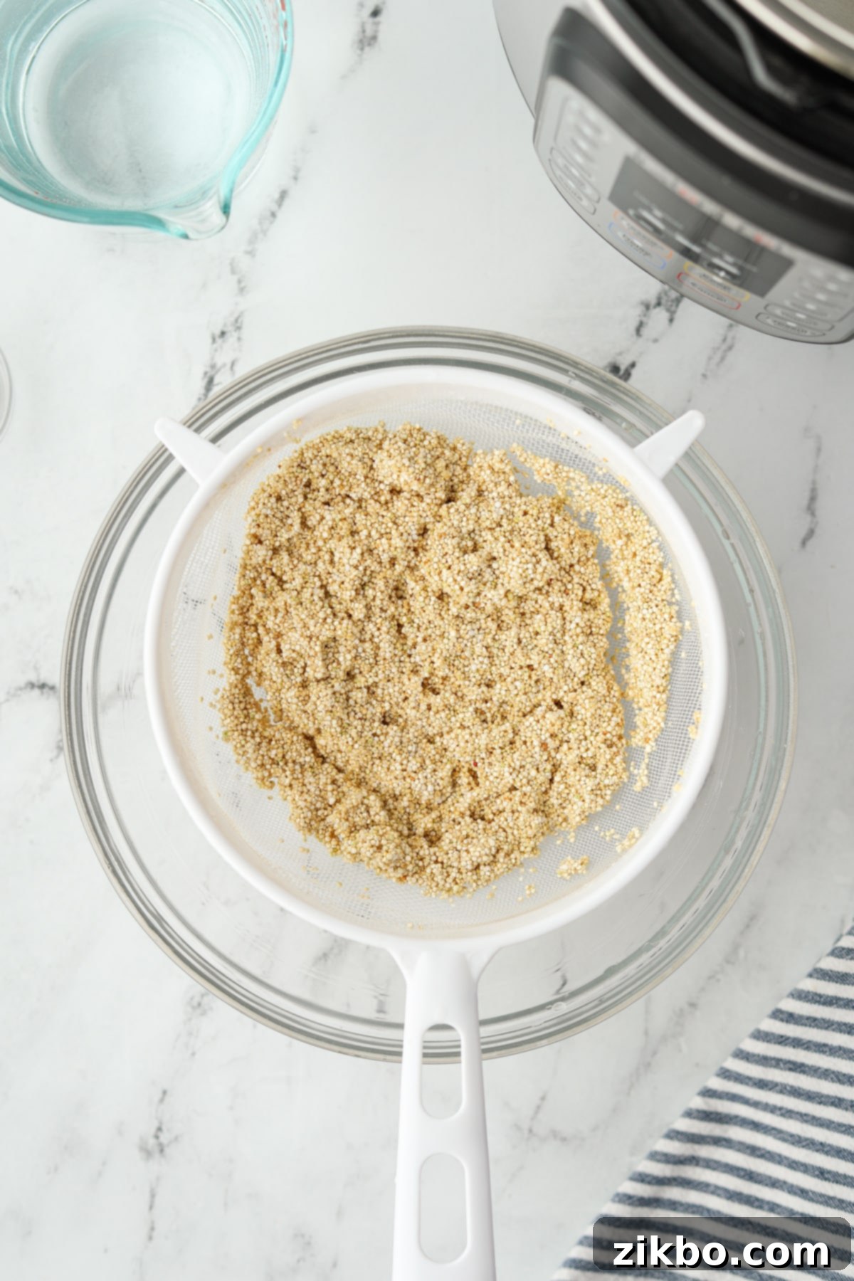 Perfect Fluffy Instant Pot Quinoa 7 Quinoa that has been rinsed in a mesh strainer.