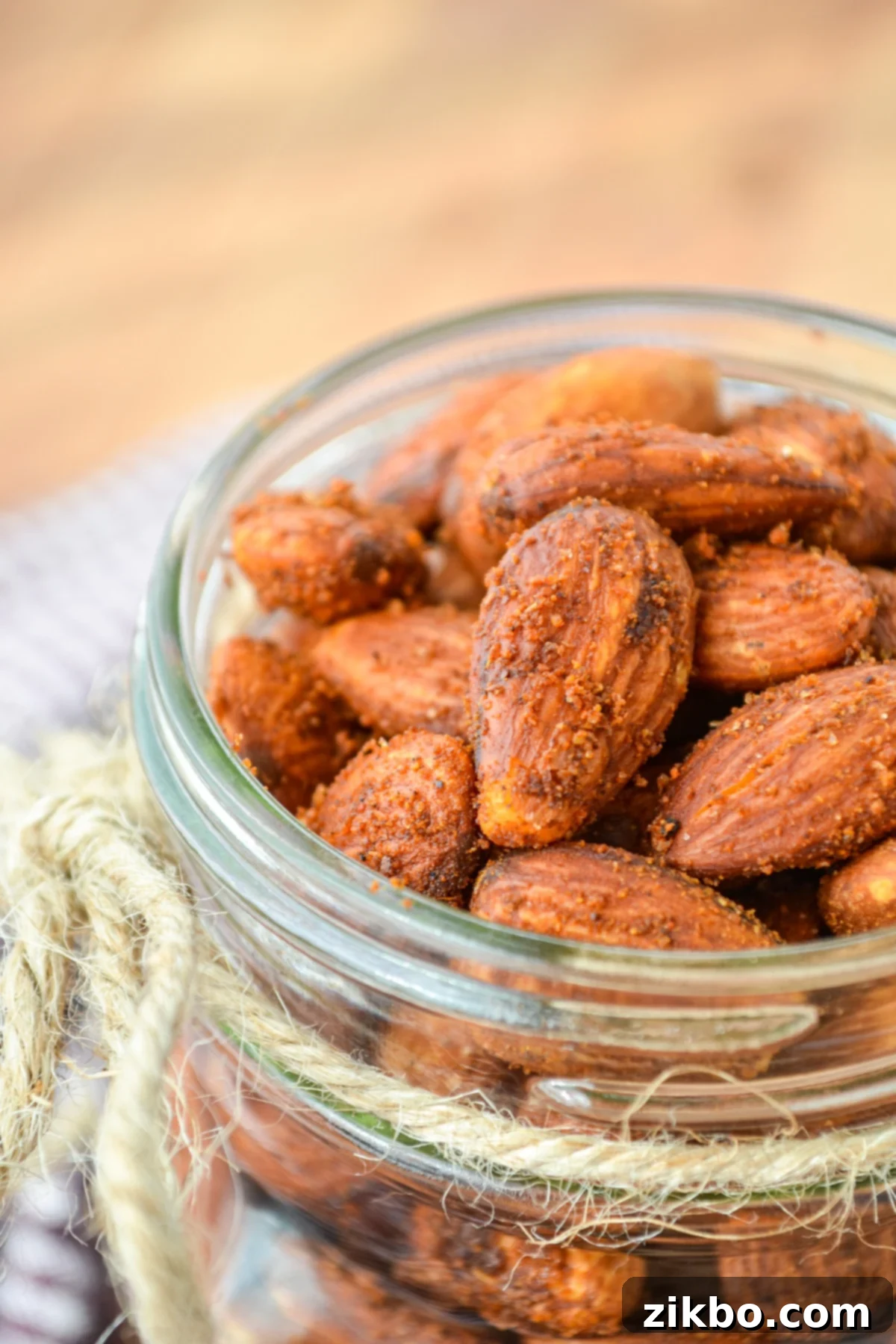A pint jar filled with roasted almonds, showcasing their crispy, golden-brown texture.