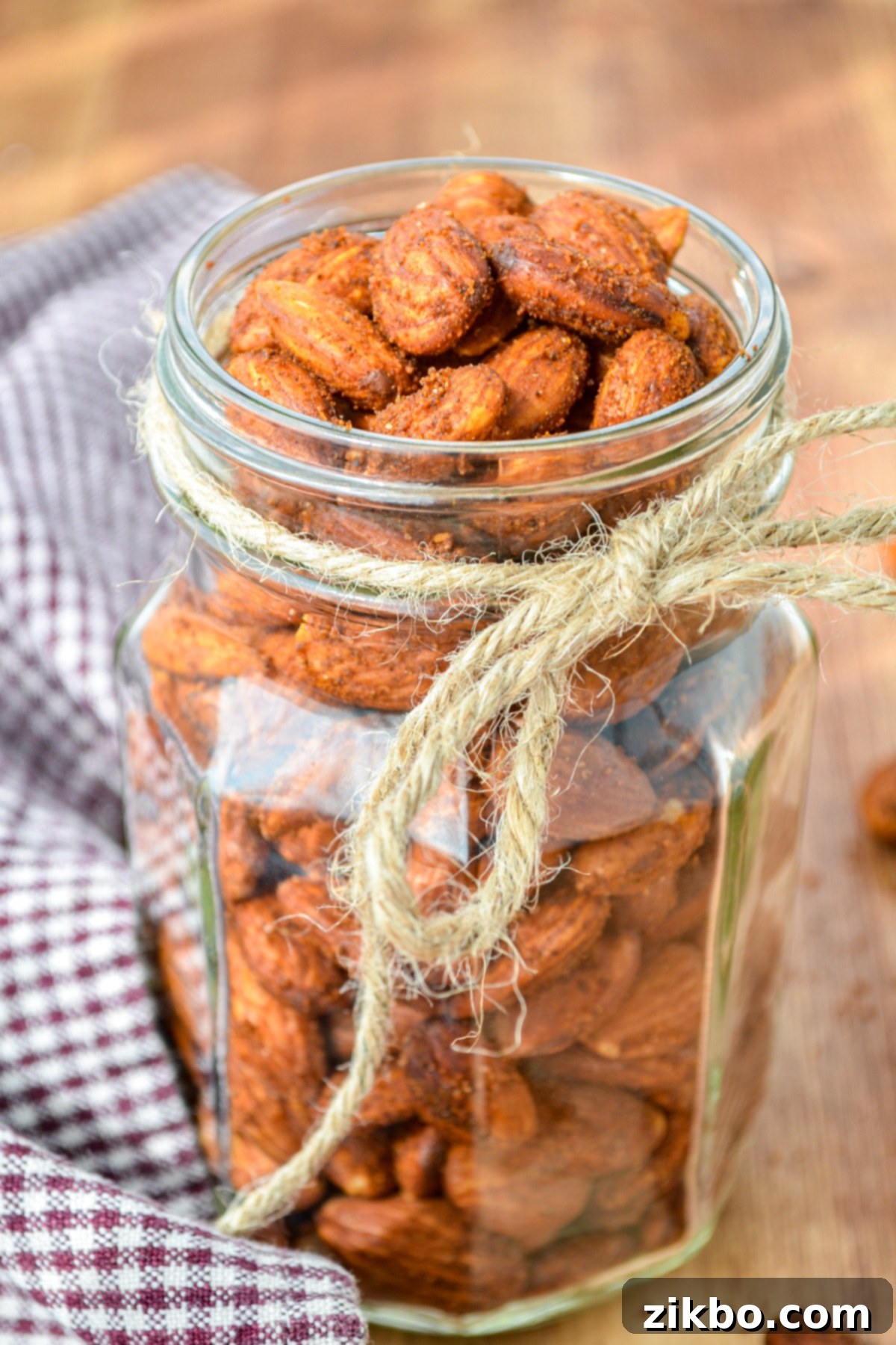 A fancy glass jar of roasted almonds, tied with twine, perfect for gifting or storage.