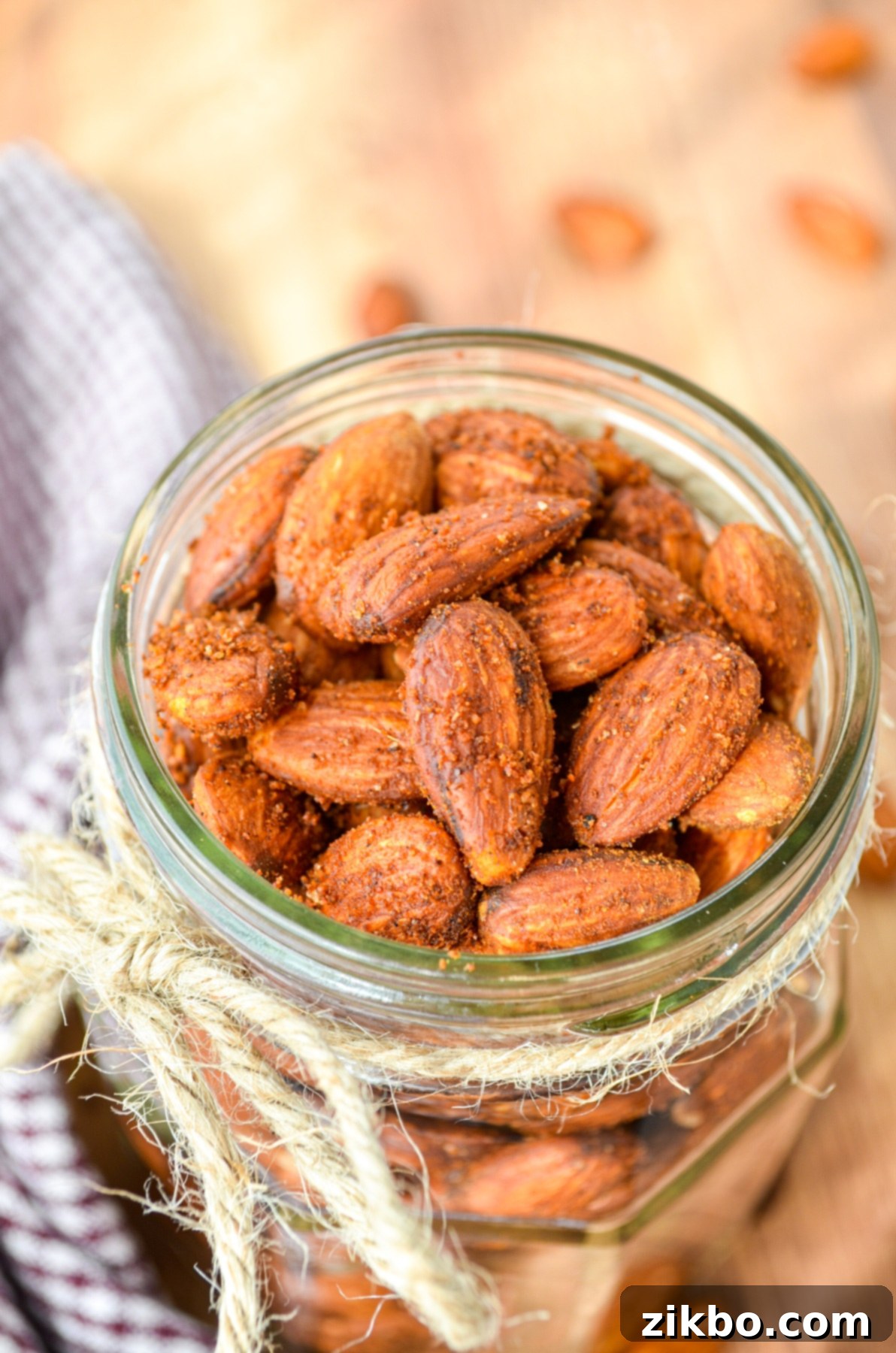 A beautiful jar full of roasted almonds, with a rustic twine tied around the rim, ready to be enjoyed.