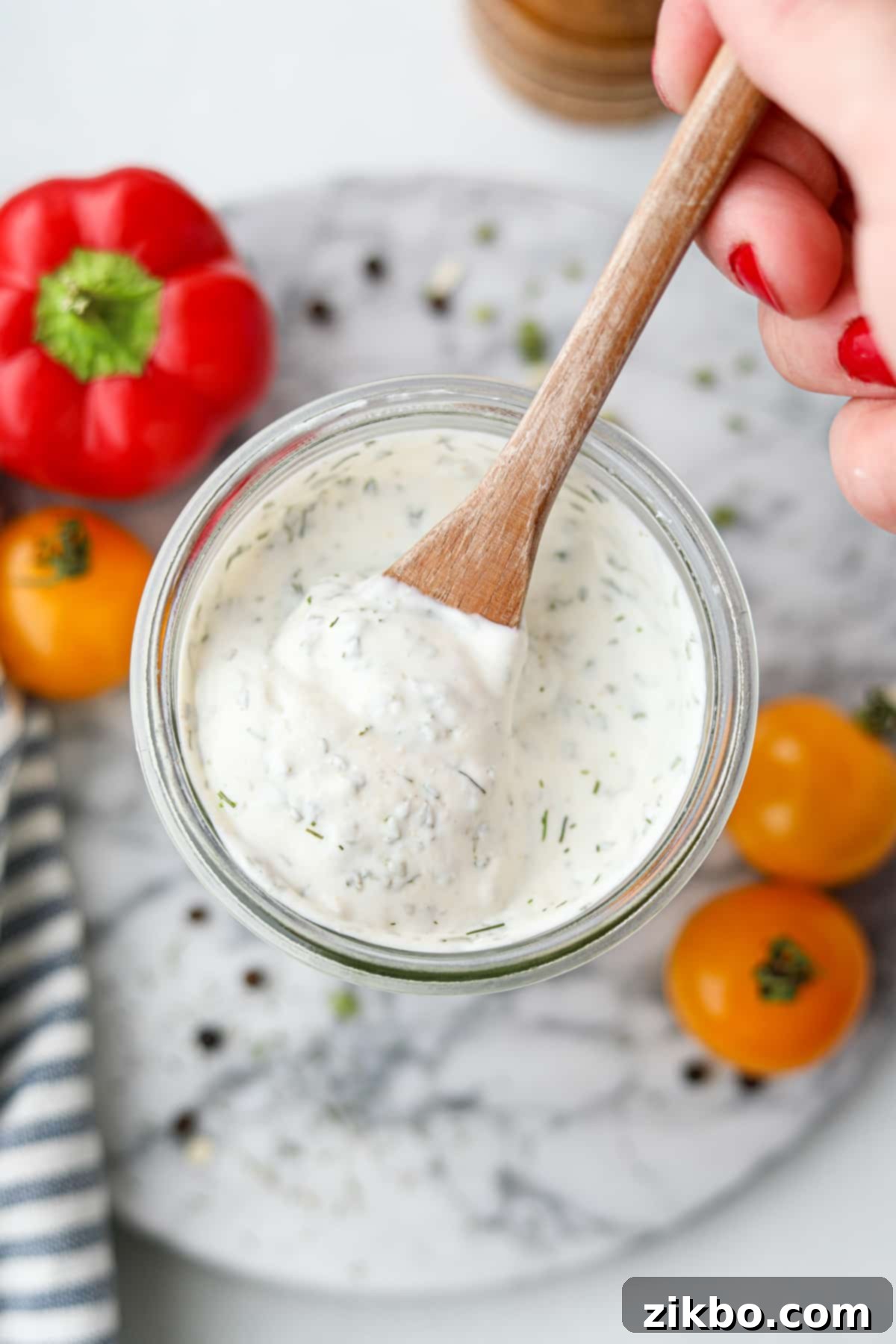 Zesty Greek Ranch Duo 8 Scooping a generous spoonful of thick, creamy homemade Greek Yogurt Ranch from a glass jar, perfectly illustrating its rich and dippable consistency.