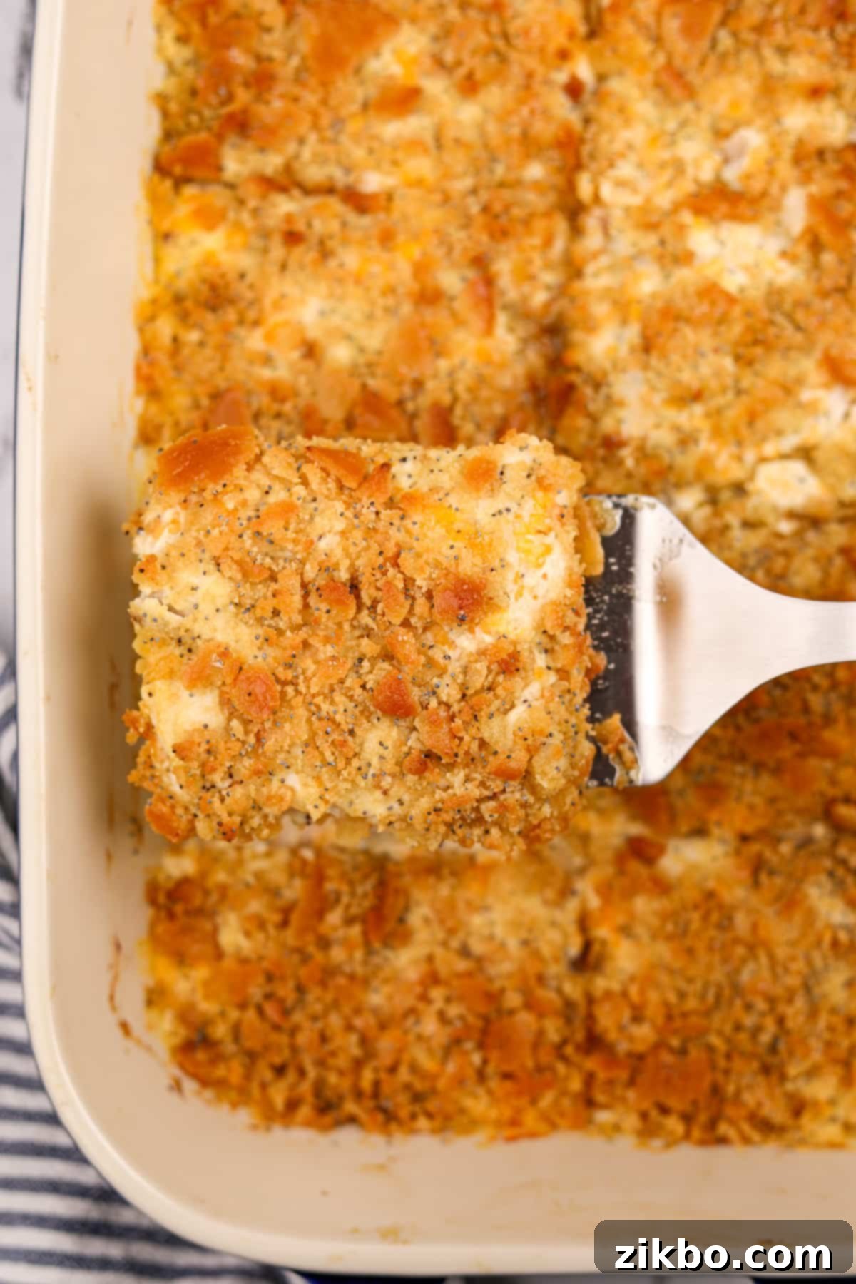 Using a spatula to lift a casserole slice from a baking dish.