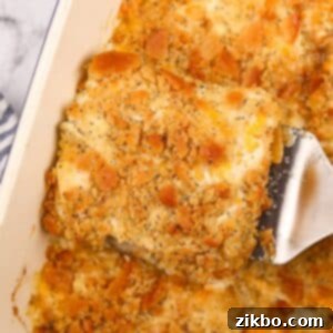 Lifting creamy chicken casserole from a baking dish using a spatula.