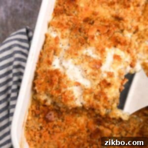 A serving of creamy gluten-free poppy seed chicken casserole being lifted from a baking dish, highlighting its delicious texture.