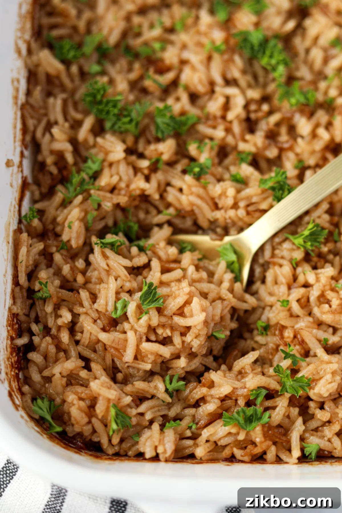 Scooping rice from a baking dish.