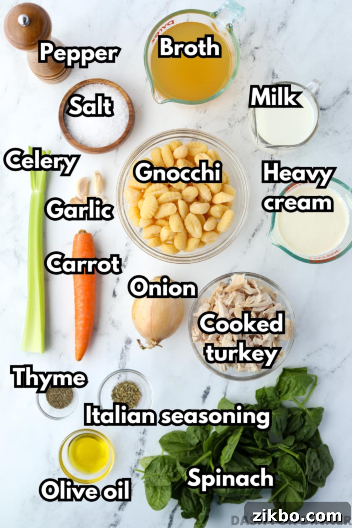 The ingredients needed to make turkey gnocchi soup, including cooked turkey, aromatic vegetables, broth, and cream, neatly arranged.