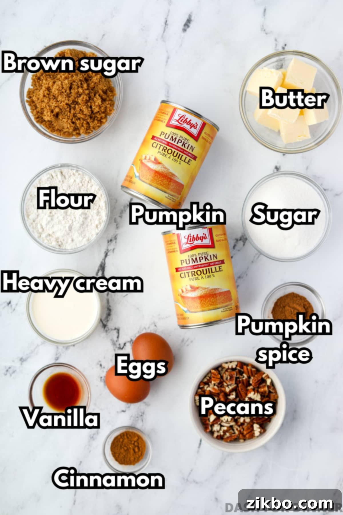 The ingredients needed to make pumpkin casserole, including pumpkin puree, heavy cream, pecans, brown sugar, and butter, laid out on a kitchen counter.