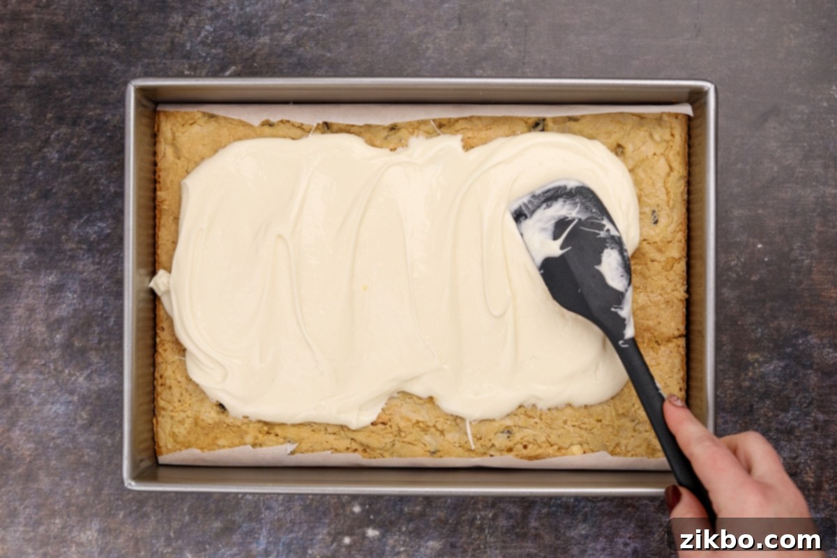 Heavenly Cranberry Bars 6 Spreading cream cheese frosting over a chilled blondie base layer.