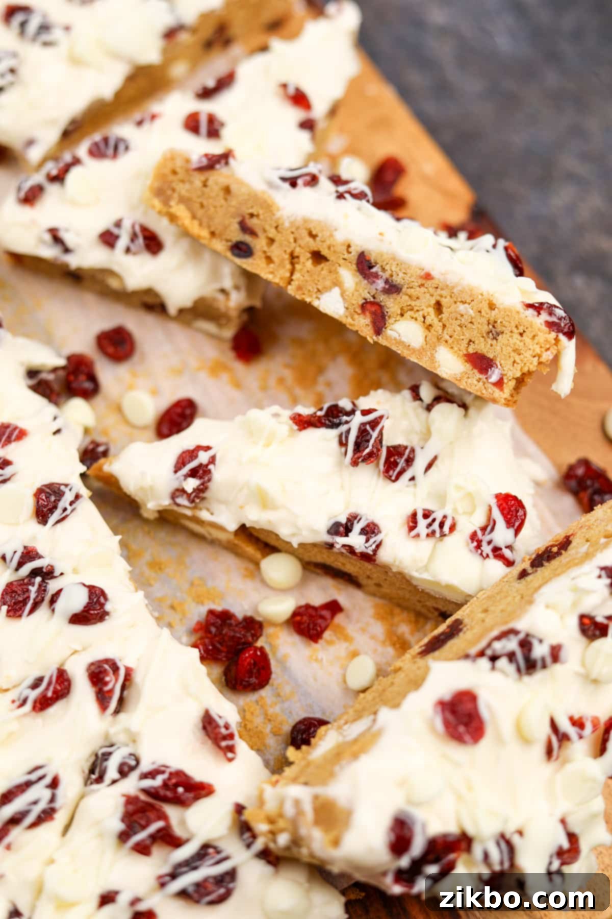 Heavenly Cranberry Bars 9 A side view of a homemade cranberry bliss bar, showing the white chocolate and cranberry dotted interior.