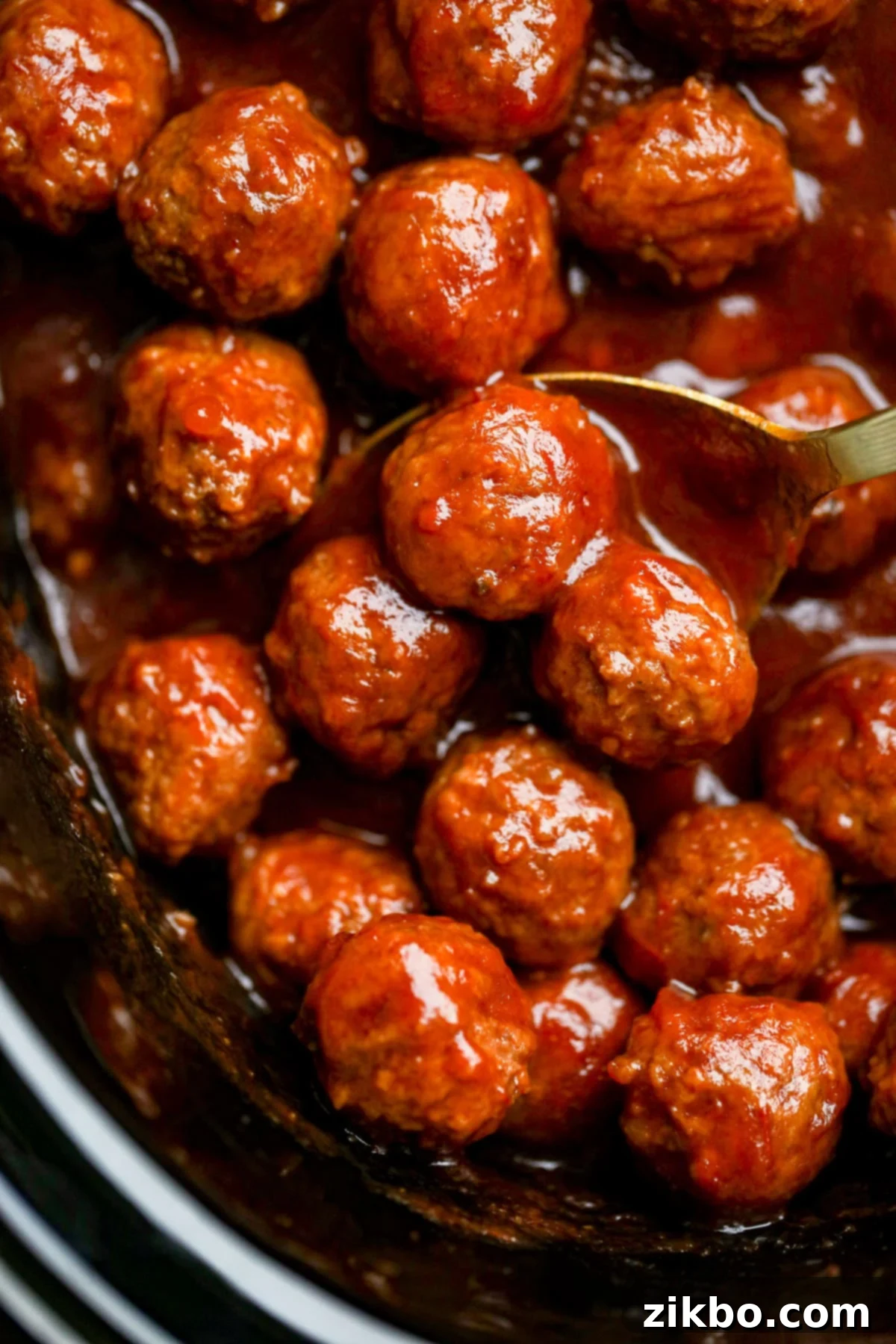 A crock pot filled with saucy cranberry meatballs, ready to be served.