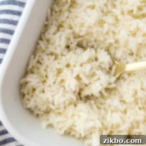 Golden Baked Rice 8 Scooping cooked rice with a spoon from a casserole dish, highlighting its fluffy and separated texture.