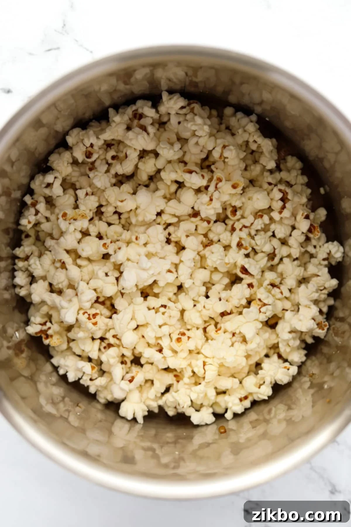 A large pot filled with freshly popped popcorn, ready for butter and salt, showing the end result of popping.