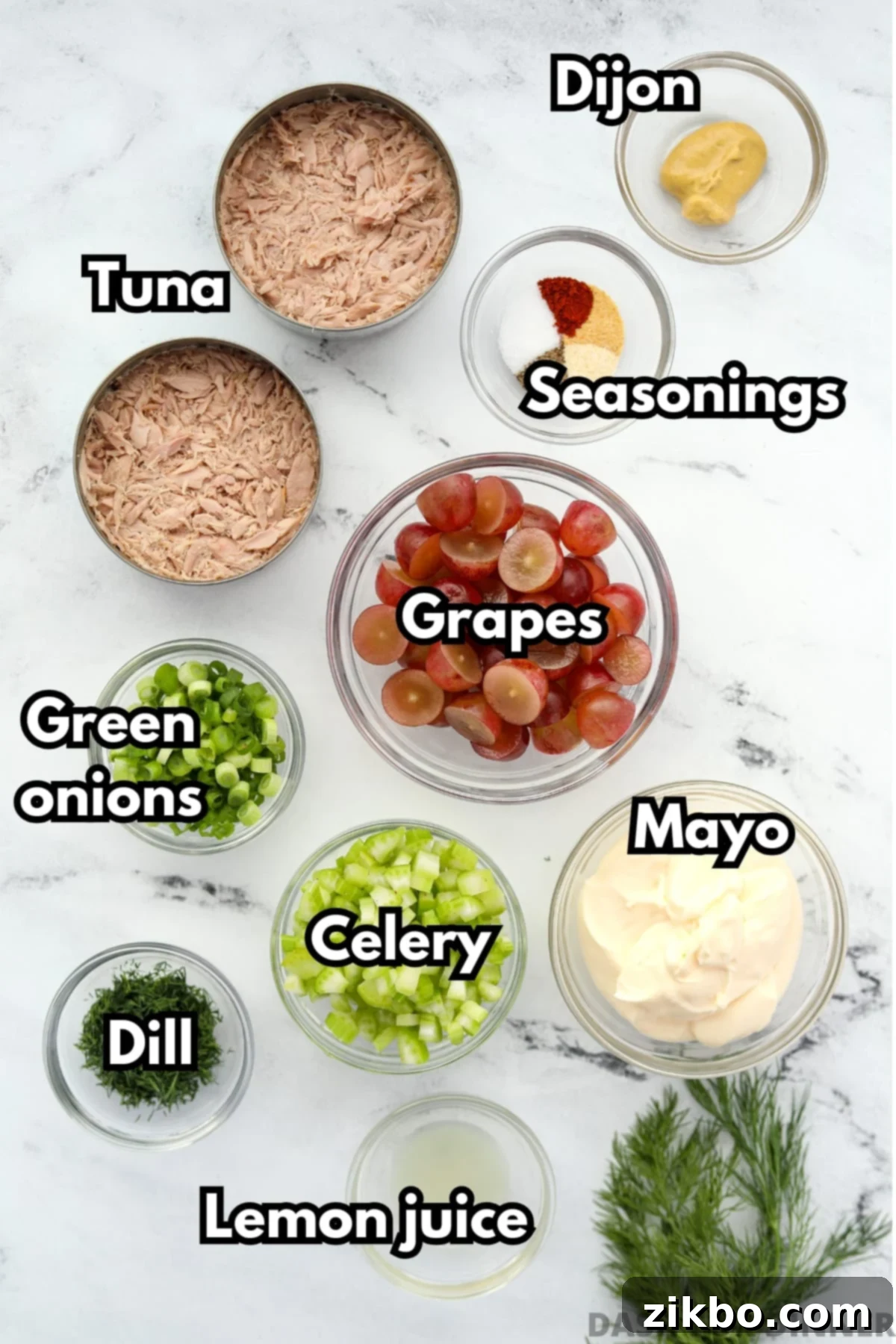 The fresh ingredients needed to make tuna salad with grapes, including celery, mayo, fresh dill, and spices.