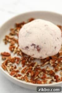 Rolling a chilled ball of soft cheese in chopped pecans.