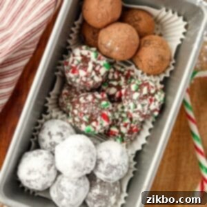 A loaf pan filled with three different types of truffles: one with cocoa, one with powdered sugar, and one with crushed candy canes.