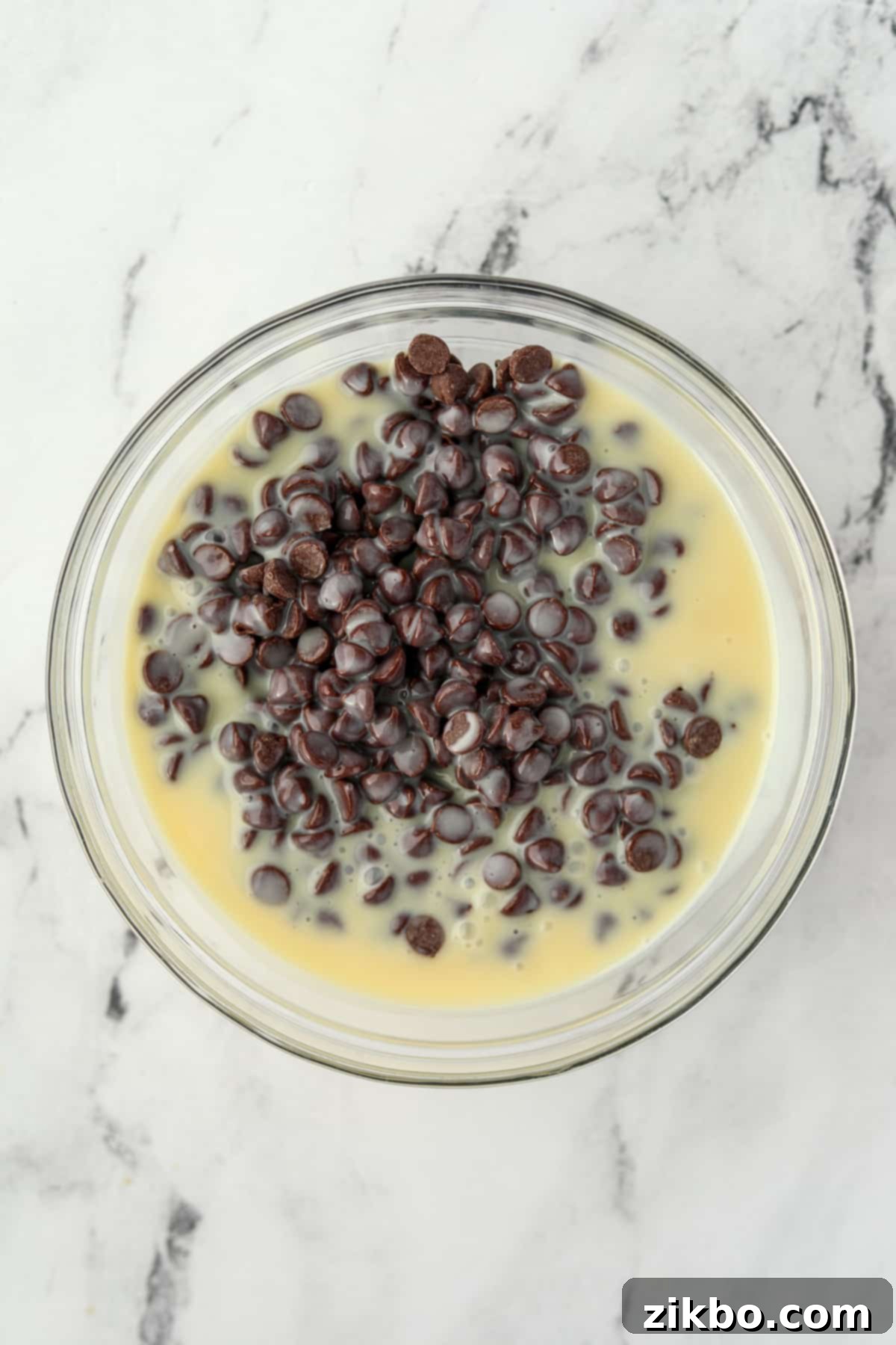 Chocolate chips and sweetened condensed milk in a microwave-safe bowl.