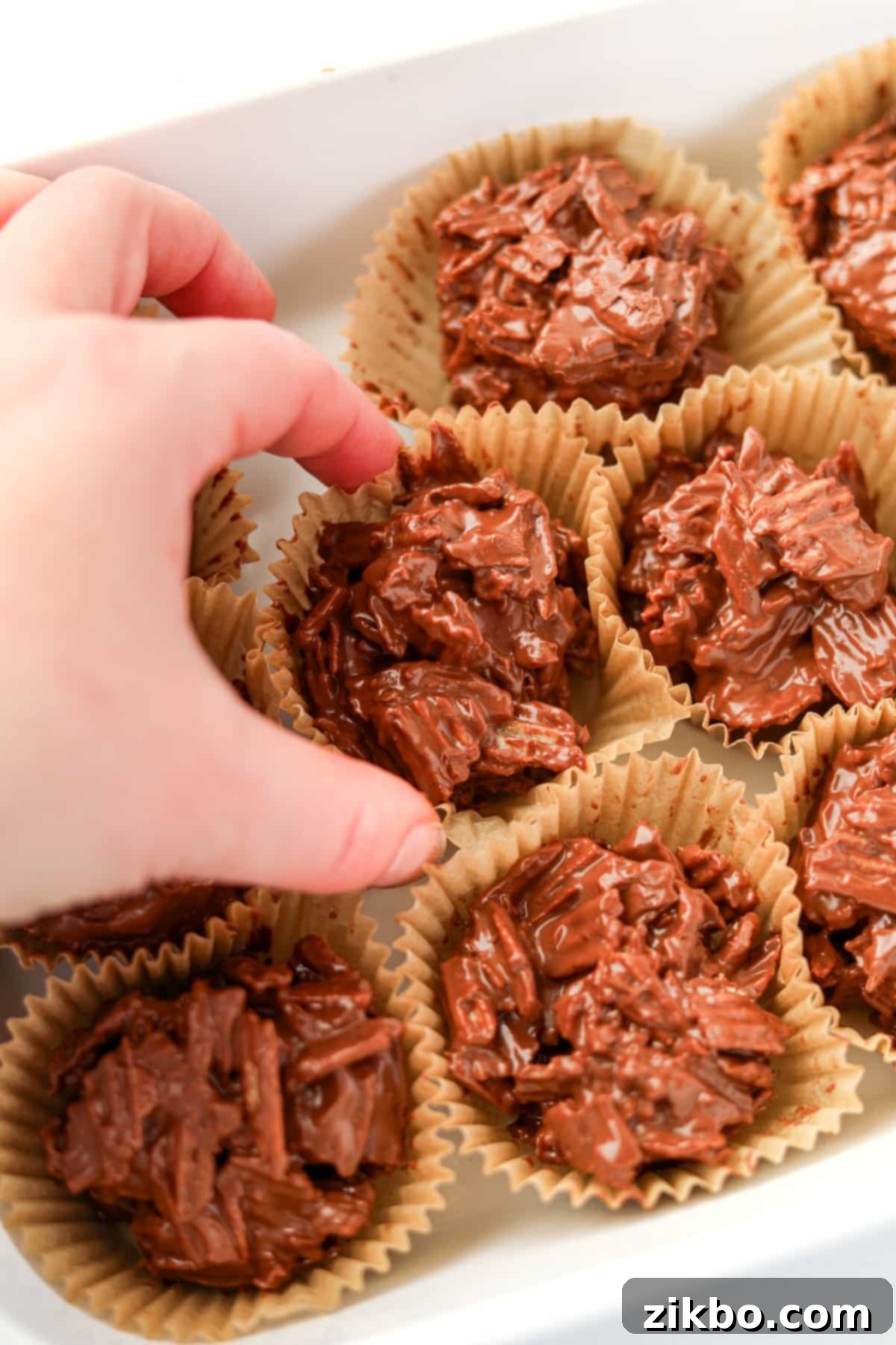 A close up of a single chocolate potato chip cluster, perfectly enveloped in its muffin liner.