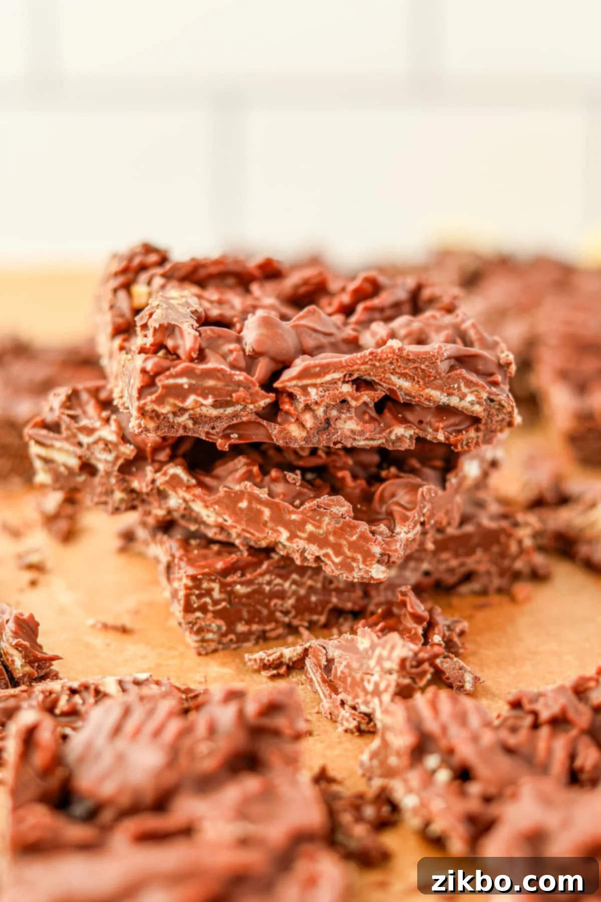 A stack of chocolate bark on a sheet of parchment paper, showcasing the irresistible combination of chocolate and potato chips.