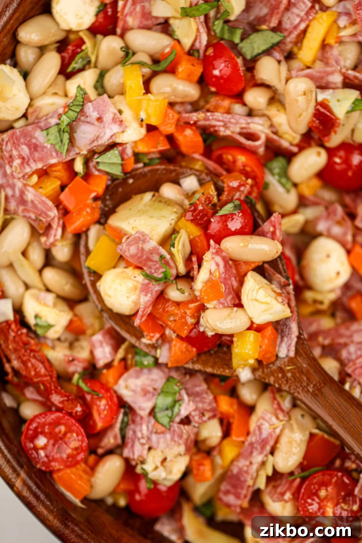 Classic Italian Bean Salad 2 A wooden spoon taking a portion of bean salad from a bowl.