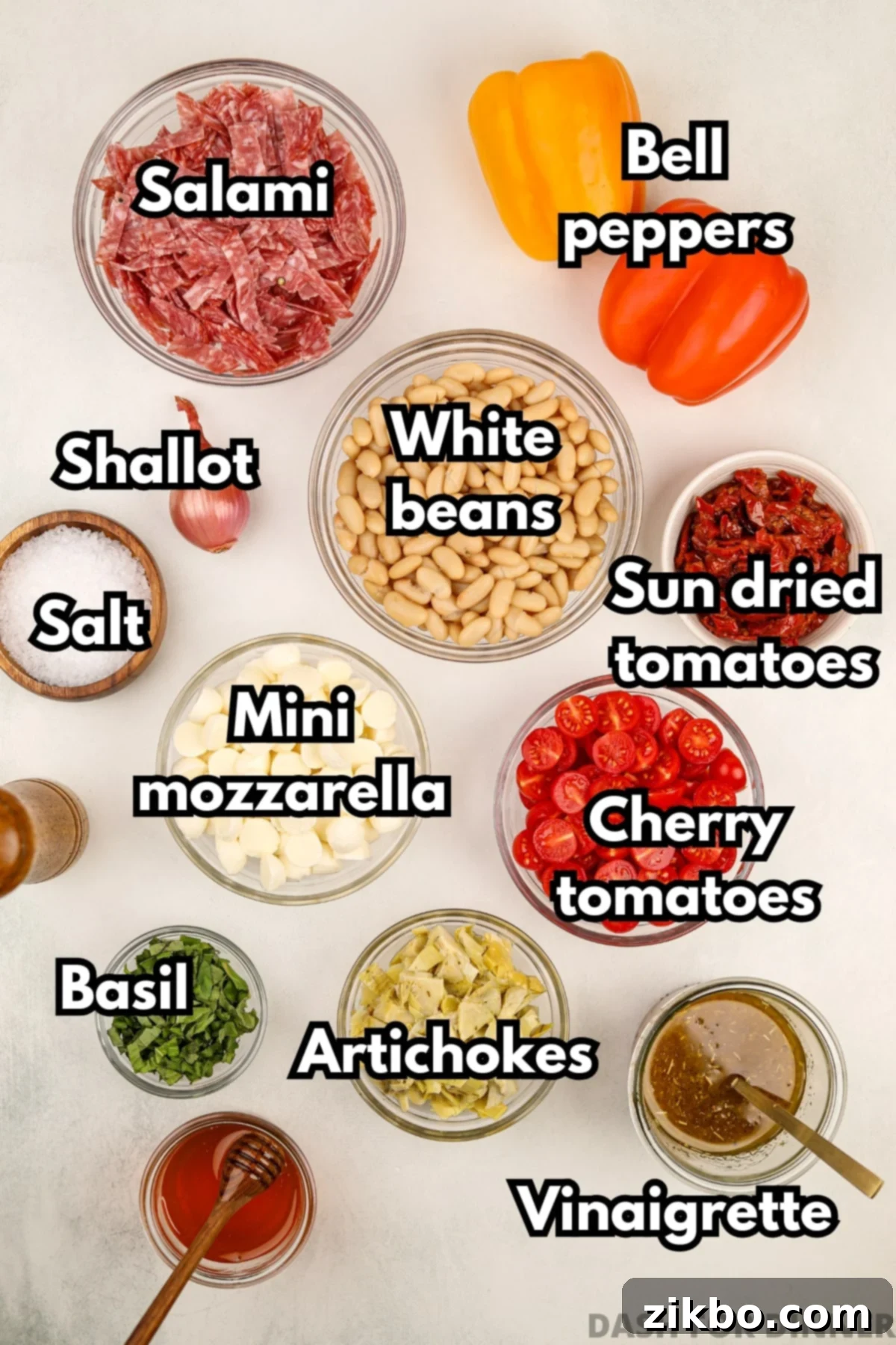 Classic Italian Bean Salad 3 The ingredients needed to make Italian bean salad, including salami, mozzarella, sundried tomatoes, and more.