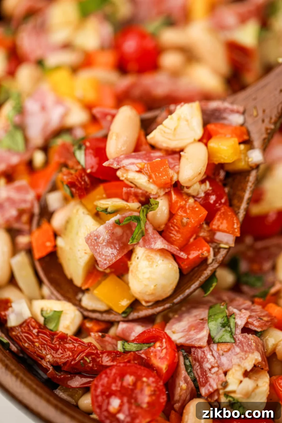 Classic Italian Bean Salad 6 A wooden spoon taking a portion of bean salad from a wooden bowl.