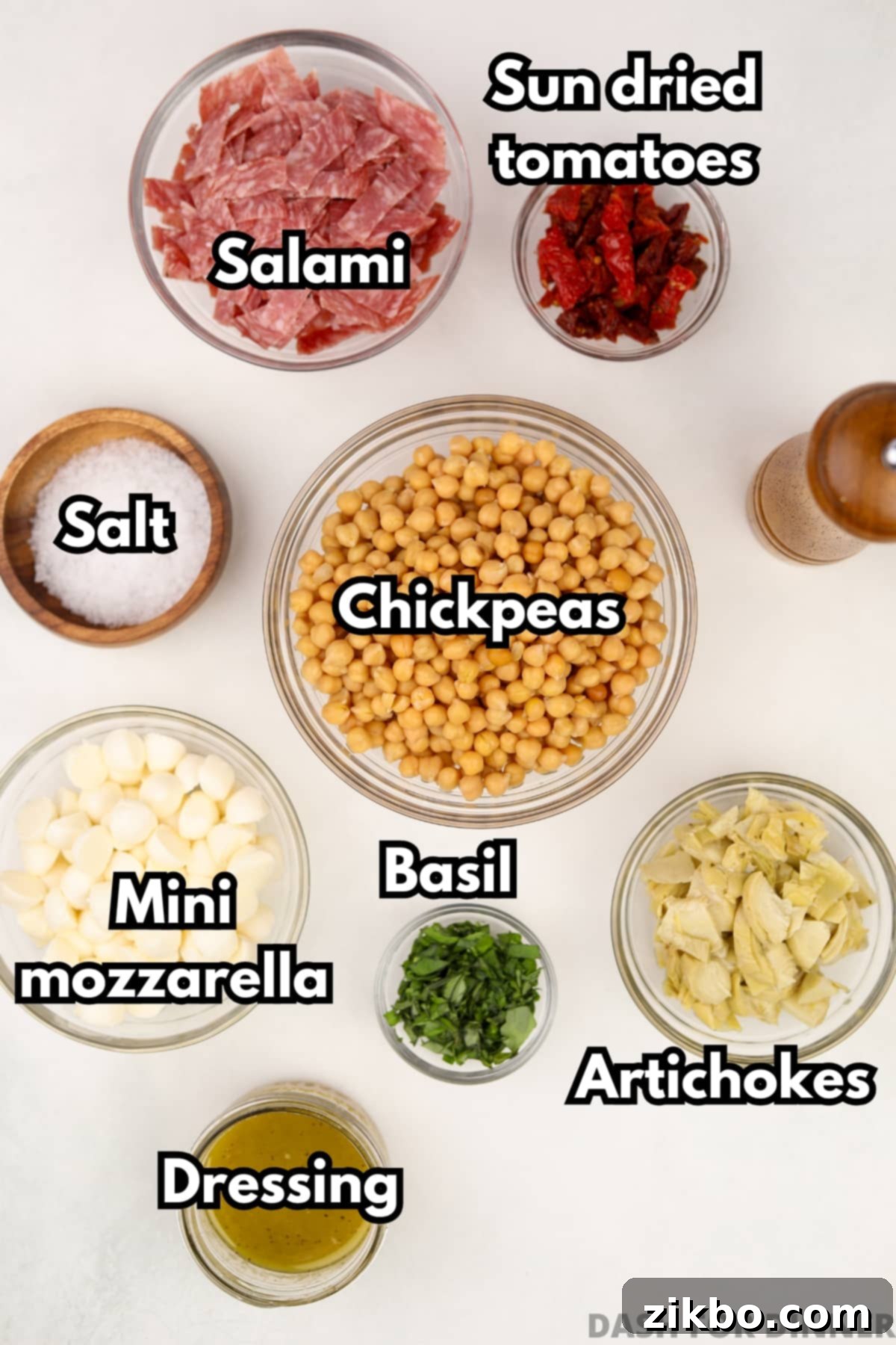 The ingredients needed to make chickpea salad: artichokes, sun-dried tomatoes, mozzarella, etc.