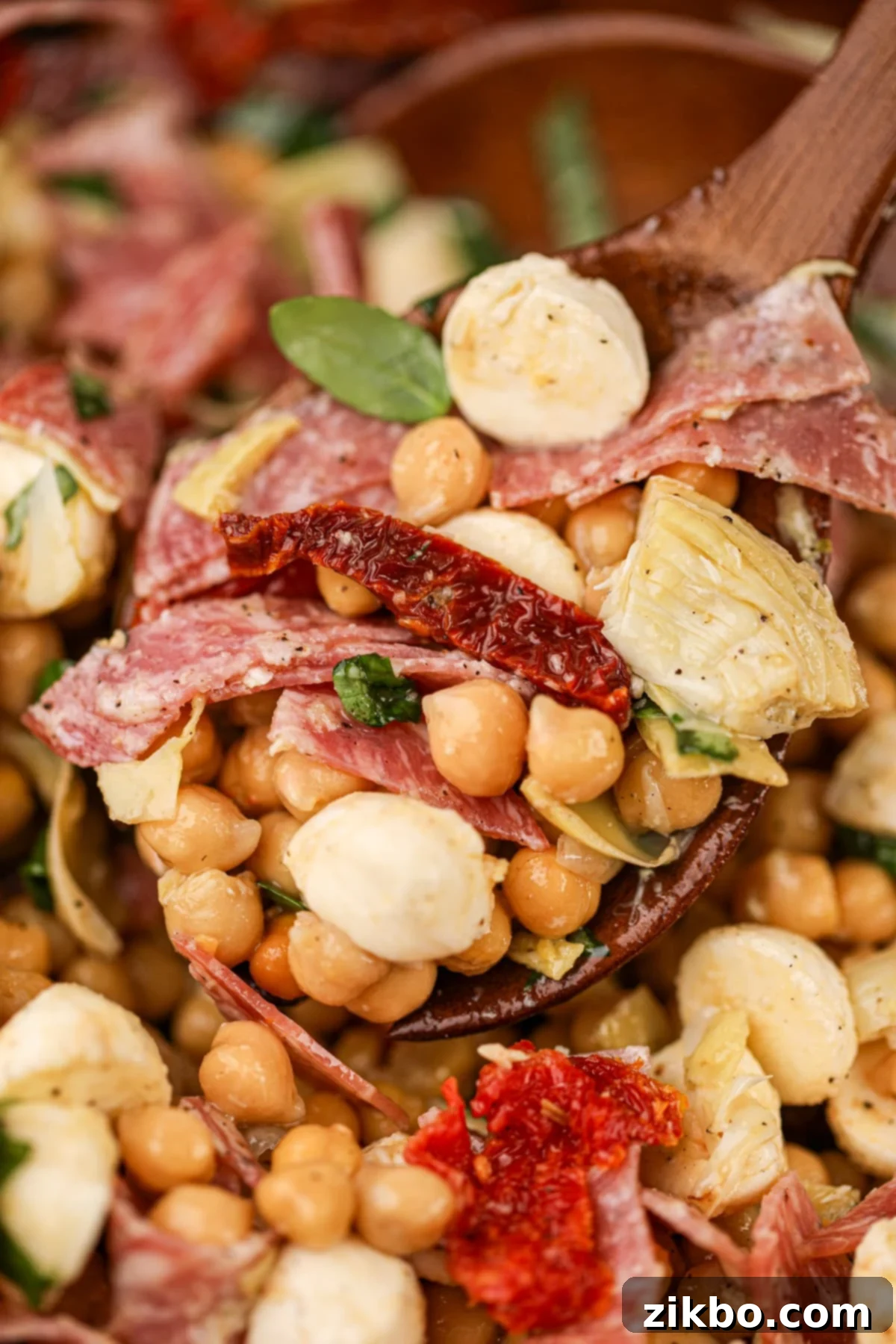 A wooden spoon scooping bean salad from a bowl.