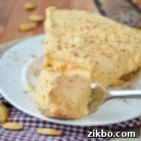 A slice of pumpkin fluff pie, with a fork sinking down into it for a bite.