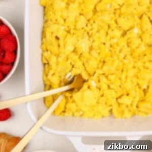 A white baking dish filled with cooked scrambled eggs.