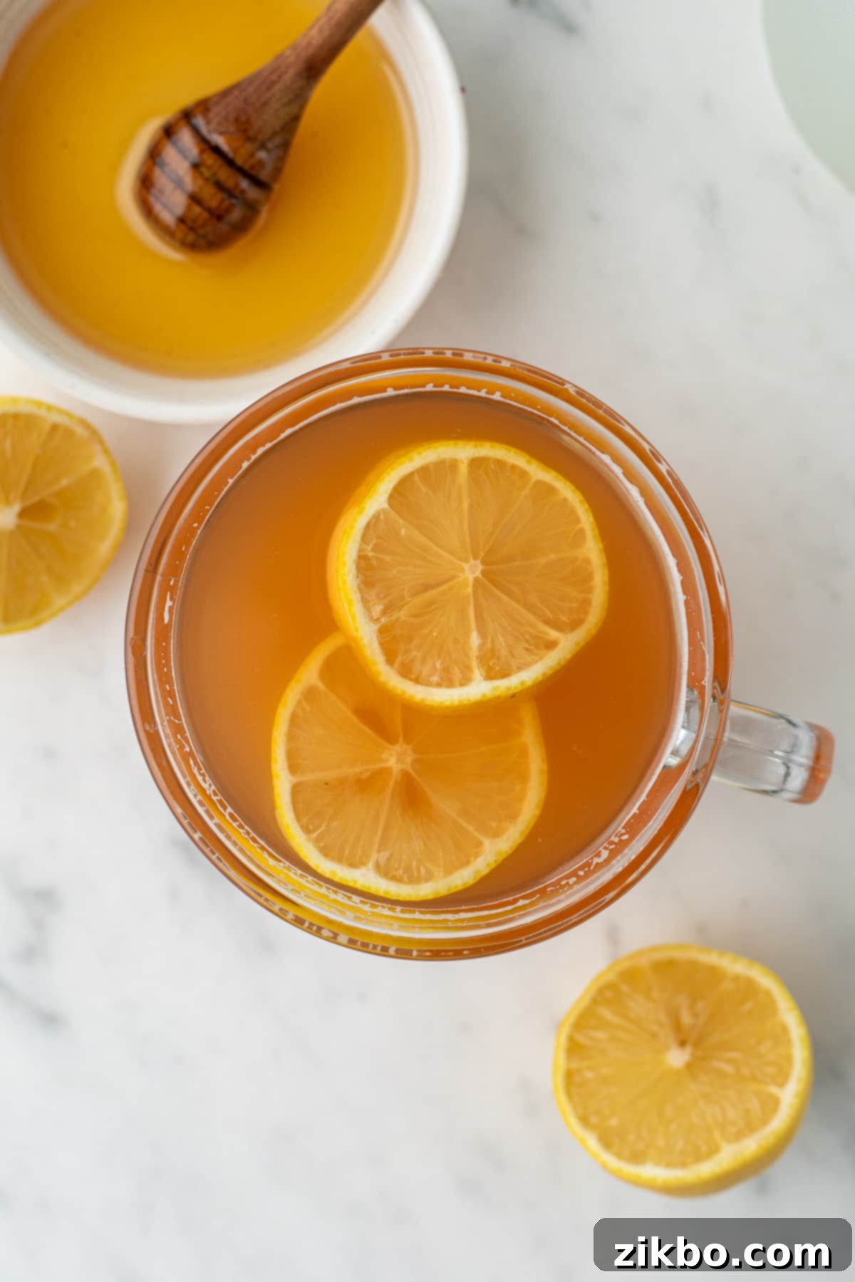 A mug of honey citrus mint tea garnished with lemon slices, ready to be enjoyed hot.