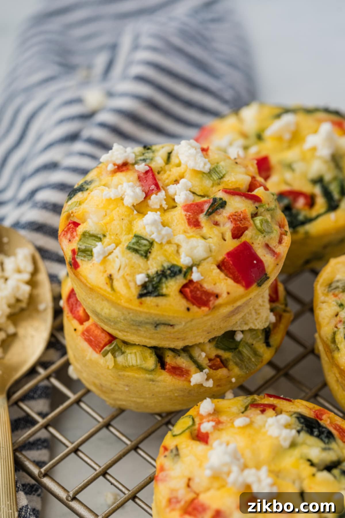 Two egg muffins stacked on top of each other on top of a wire cooling rack.
