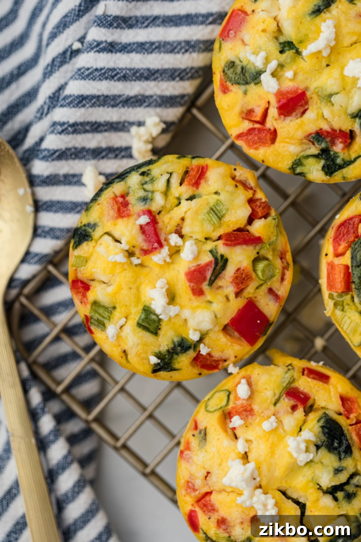 A feta and spinach egg muffin cooling on a wire rack.