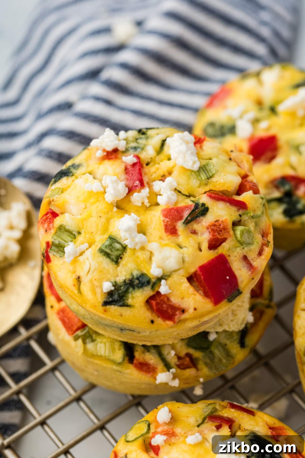 Two spinach egg bites stacked on a wire rack.