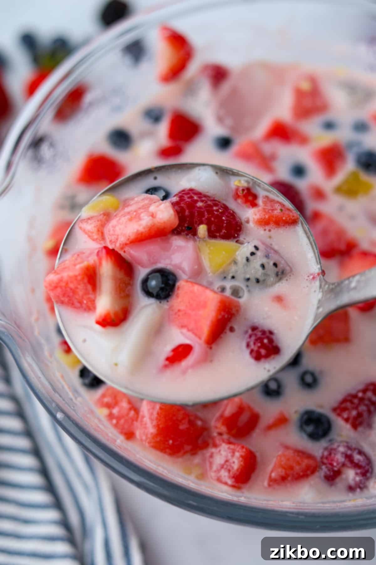 Hwachae: Korea's Vibrant Fruit Refreshment 7 A ladleful of watermelon and berry punch coming from a punch bowl.