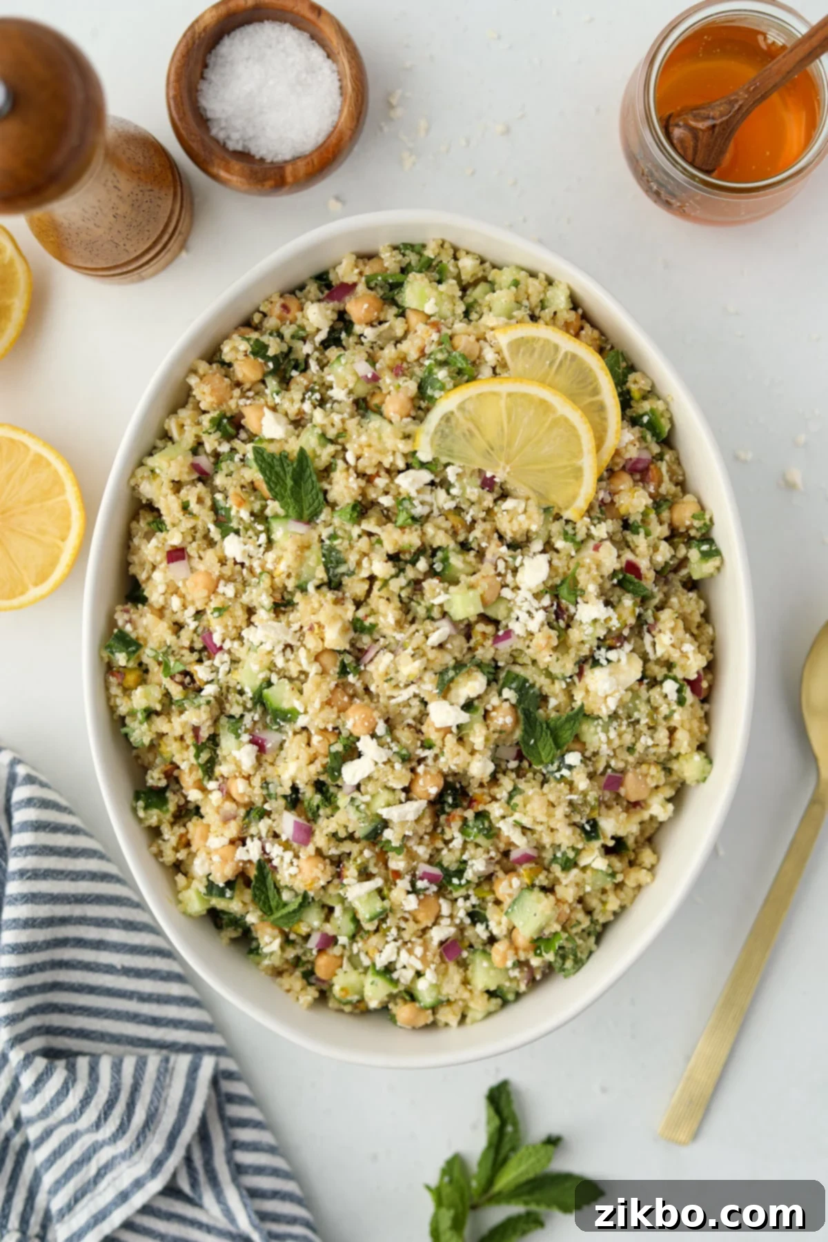 Quinoa salad in a large bowl garnished with lemon and mint, perfectly chilled and ready to be served.