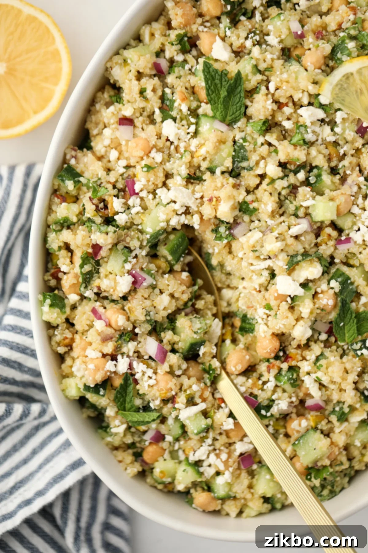 Scooping a spoon into a vibrant quinoa salad, showcasing the texture and mixed ingredients.