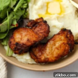 Crispy and Juicy Air Fryer Chicken Thighs 8 Two crisp chicken thighs on a bed of mashed potatoes.