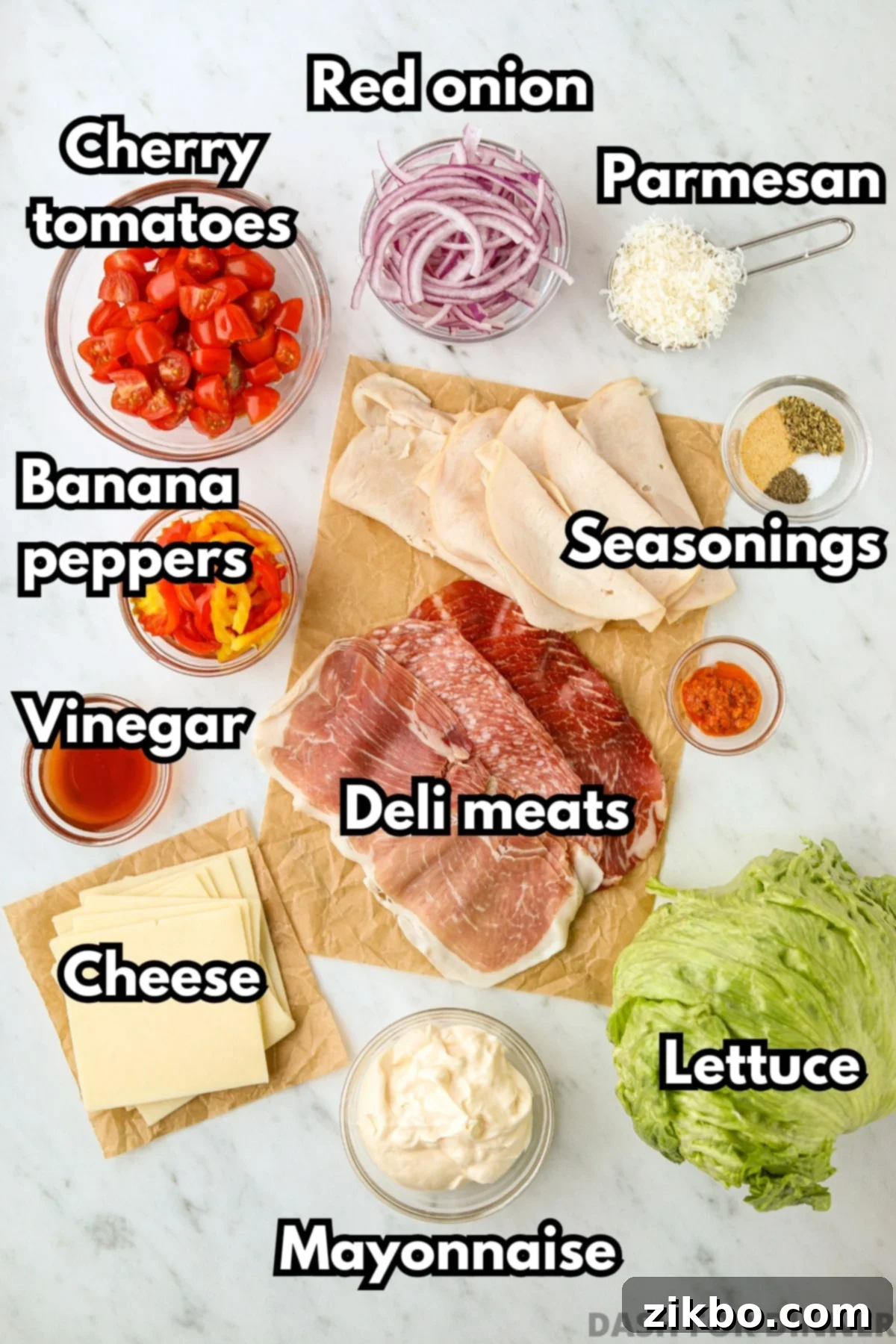 The ingredients needed to make grinder salad, including deli meats, cheese, banana peppers, mayo, etc.