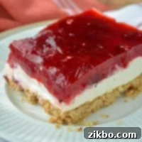 A slice of a three layer dessert with a pretzel base.