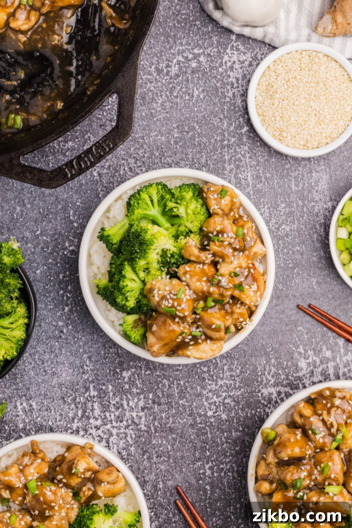 A bowl with broccoli and chicken stir fry, with several small bowls surrounding the outer frame.