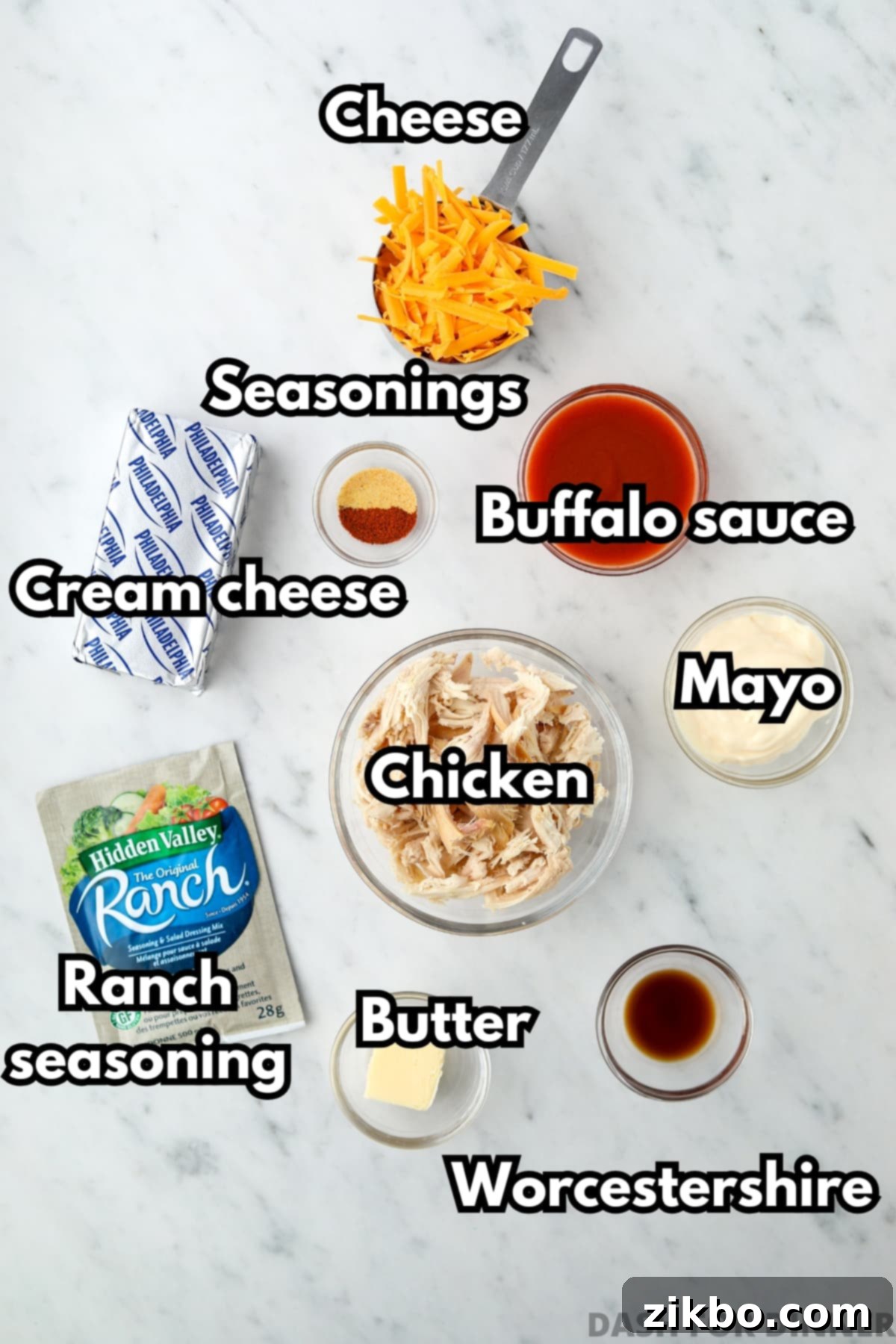 The ingredients needed to make buffalo chicken dip, including cream cheese, chicken, cheese, and buffalo sauce.