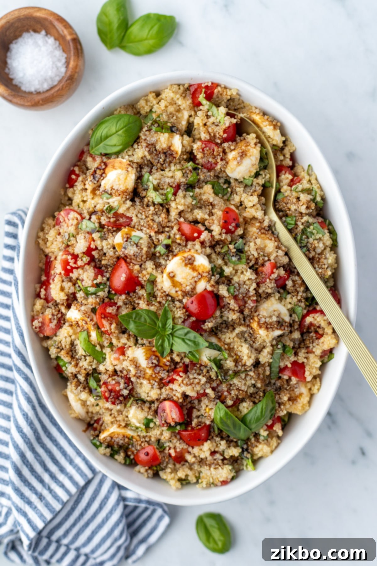 Fresh Caprese Quinoa 2 A bowl of quinoa salad garnished with fresh basil and a drizzle of balsamic glaze.
