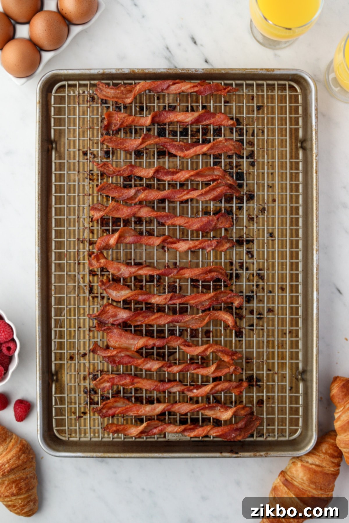 A baking sheet filled with crispy twisted bacon slices.