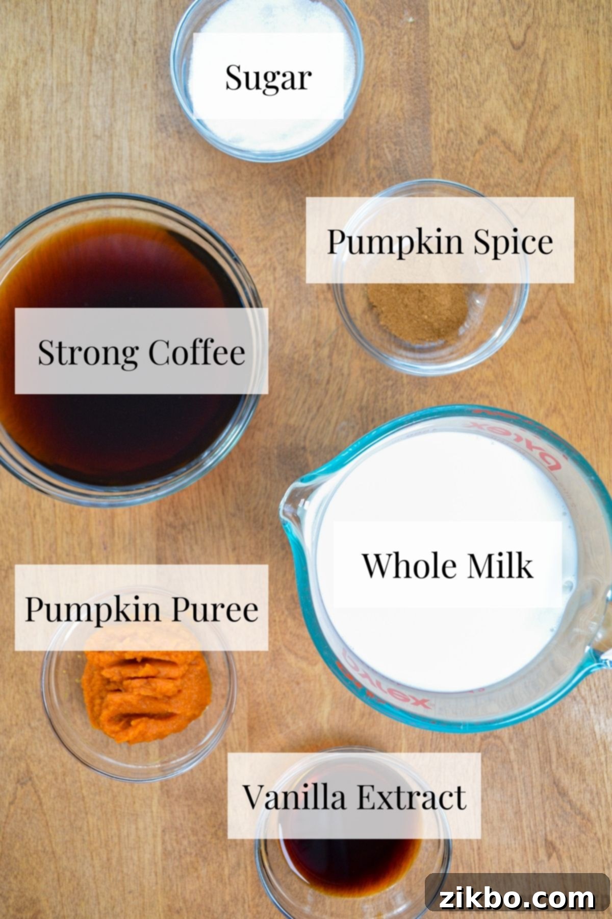 A selection of fresh ingredients including whole milk, pumpkin puree, freshly brewed coffee, aromatic pumpkin pie spice, white granulated sugar, and vanilla extract, all perfectly arranged for making an Instant Pot Pumpkin Spice Latte.