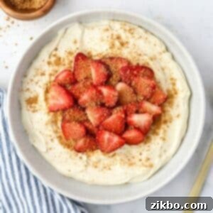 A bowl of fluffy yogurt topped with sliced strawberries and a sprinkling of graham cracker crumbs.